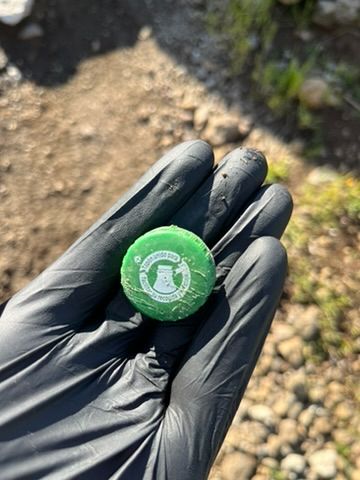 Tapón de botella de plástico en mi mano en el que se lee "tapón unido facilitar su recogida y reciclaje"