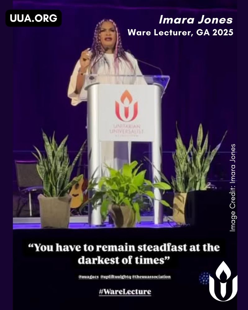 Imara Jones, a Black trans woman with long pink and purple braids, stands behind a clear podium with the UUA flaming chalice logo during the 2025 Ware Lecture at the Unitarian Universalist Association's General Assembly. She wears a flowing white dress and gestures passionately as she speaks. The background is lit in deep purple, and potted plants sit on the stage beside her, along with a guitar leaning against a chair. A quote on the image reads, “You have to remain steadfast at the darkest of times.” Additional text includes “Imara Jones, Ware Lecturer, GA 2025” and “http://UUA.ORG .”