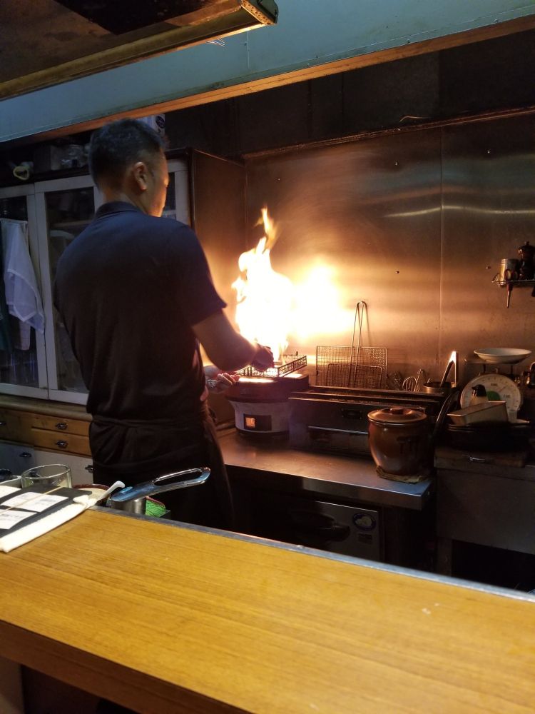 Chef flash-frying some chicken (still rare on the inside)