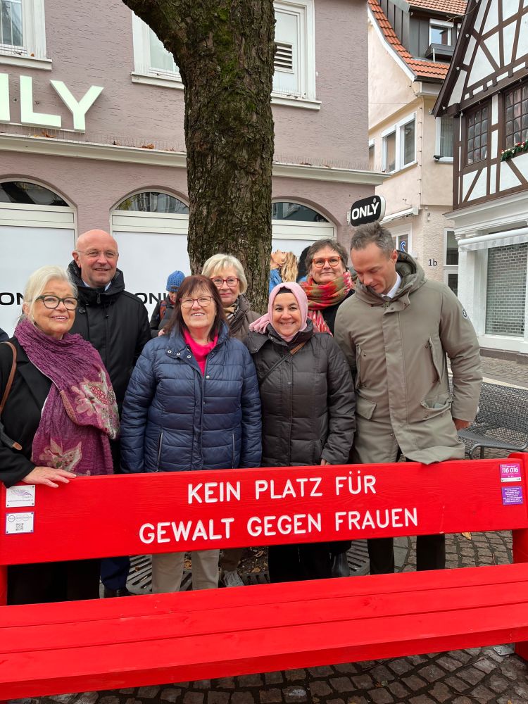 Internationale Tag gegen Gewalt an Frauen,
roter Bank und Fahnen , für ein Zeichen , das kein Gewalt, kein Blut von Frauen fließen soll. 