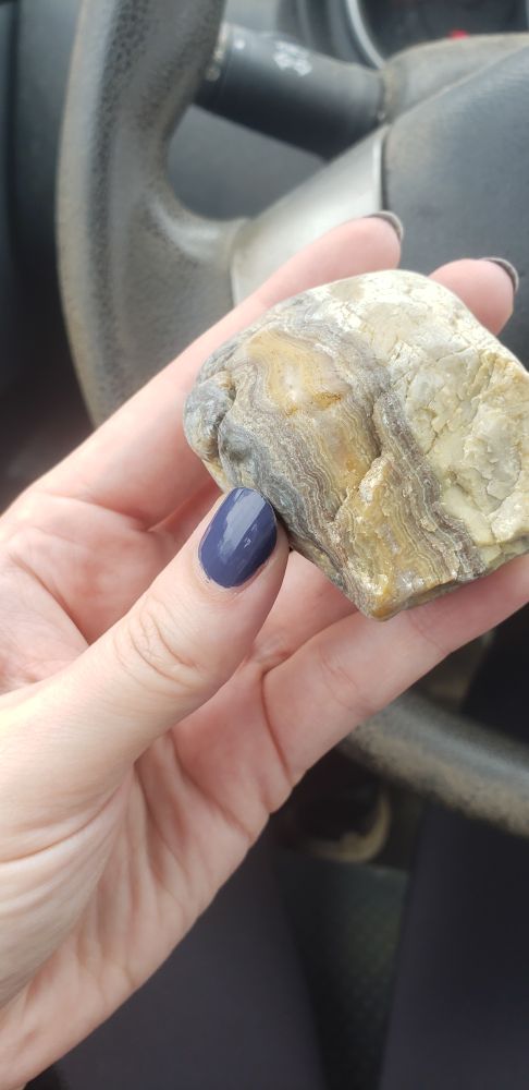 A tan and cream-colored stone with wavy banding.