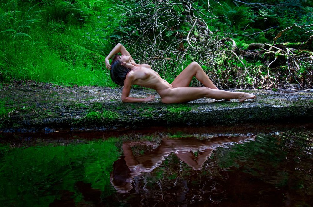 a naked woman by a river