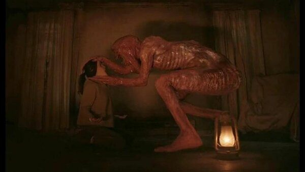 A huge humanoid monster, about three times the size of a normal human, covered in blood and slimy stuff, crouching in front of Rose. It's... kind of underwhelming.