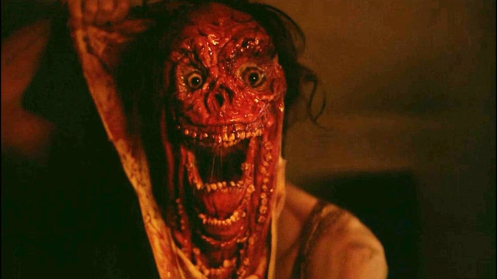 A bloody-faced, disfigured monster with a huge mouth full of teeth that contains a huge mouth full of teeth that contains a huge mouth full of teeth.