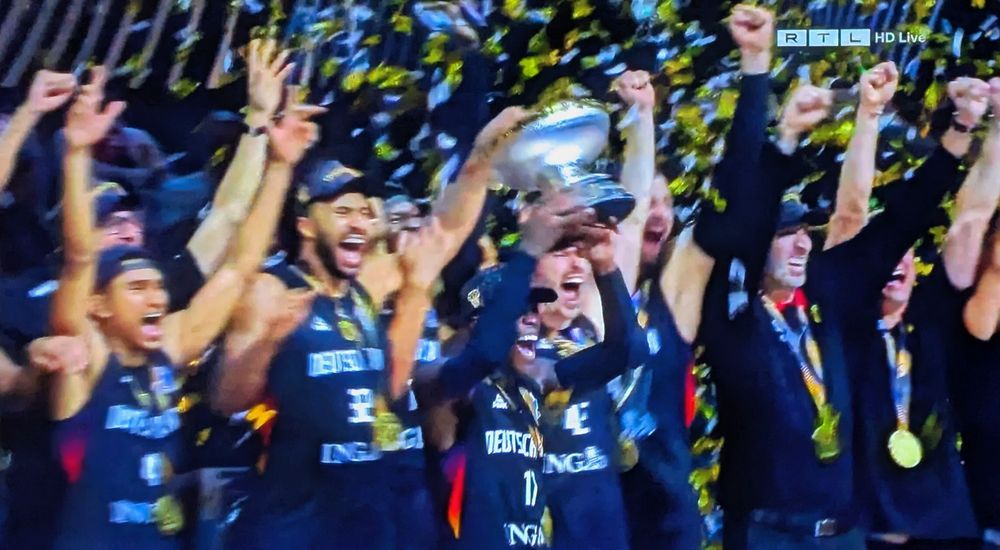 Die deutschen Basketballer halten den EM Pokal hoch.