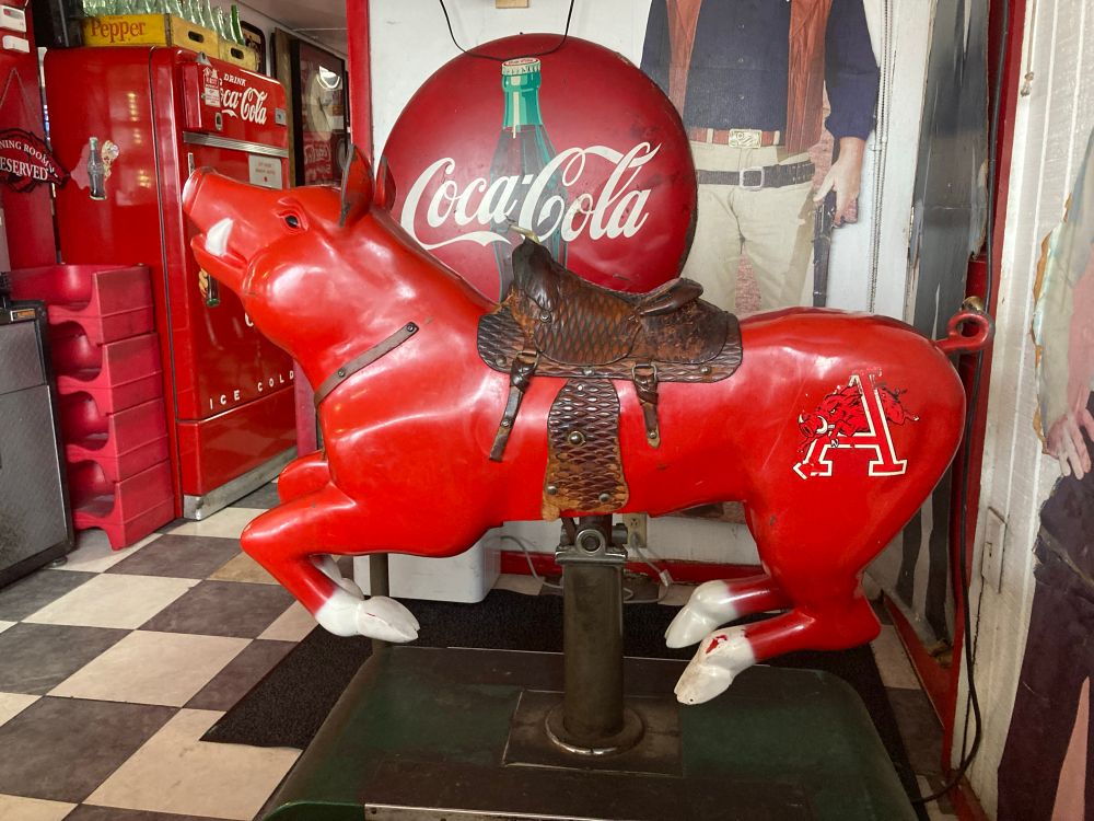 Coin operated kids arcade ride, but instead of a horse it’s a red Razorback hog.