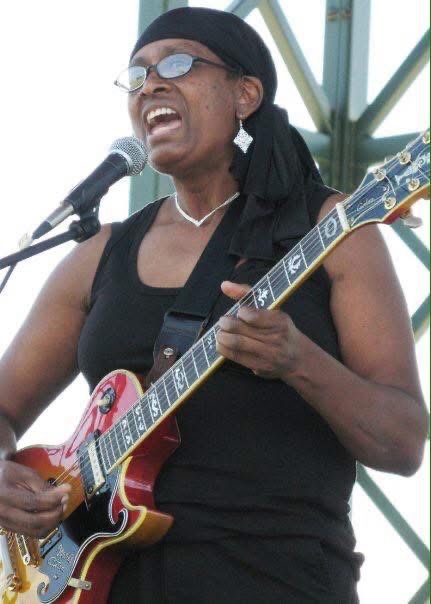 Essie playing electric guitar and singing 