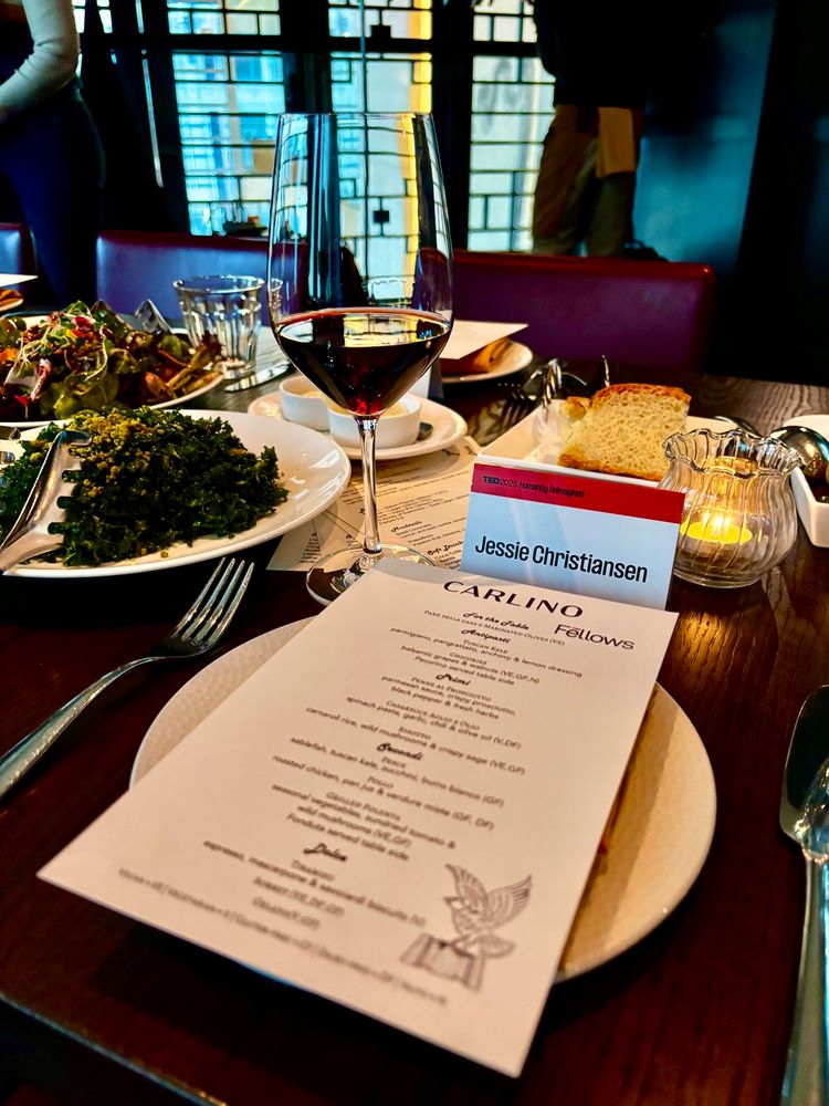 Menu and glass of red wine with a red nameplate that says Jessie Christiansen