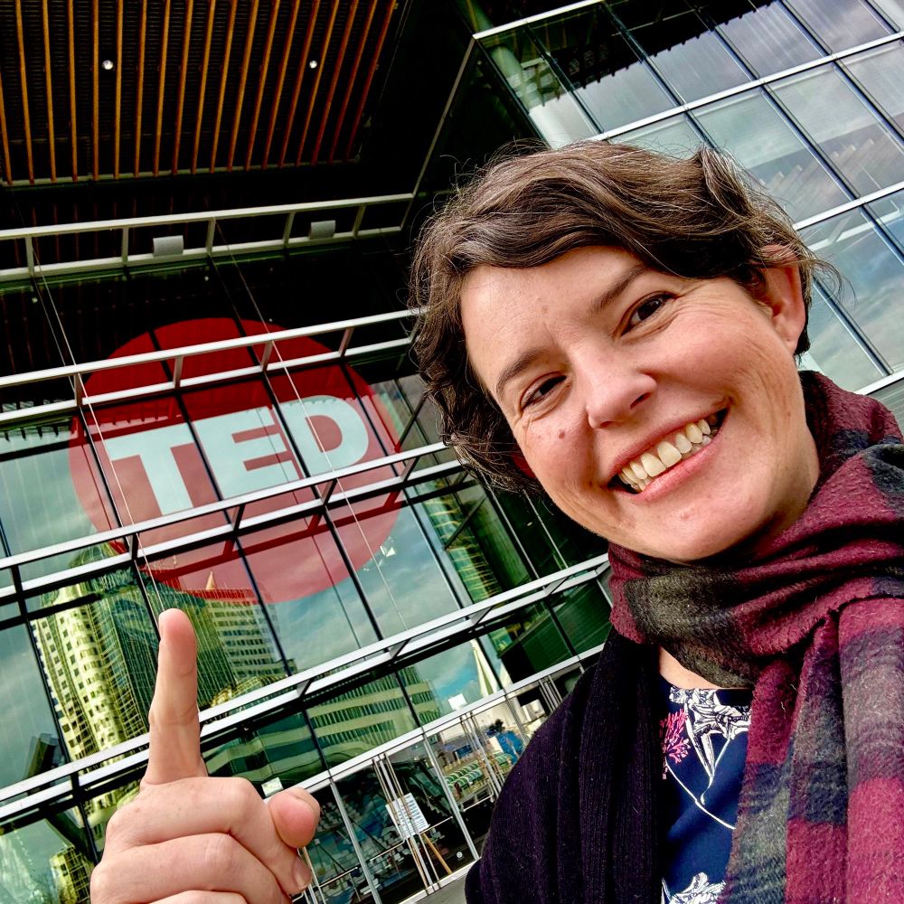 Selfie of Jessie in front of a big red circle that says TED