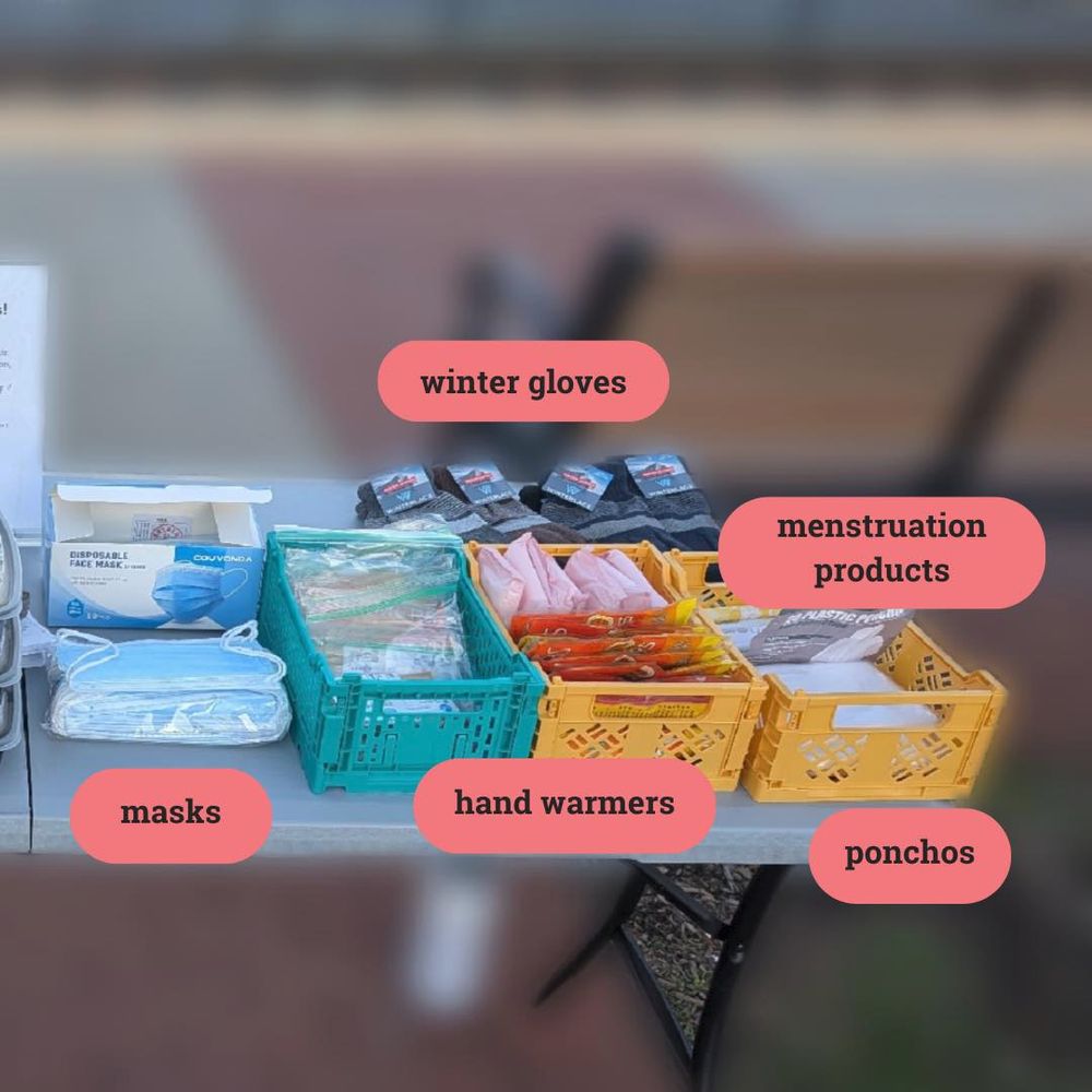 Table with winter gloves, hand warmers, masks, ponchos, and menstruation products. 