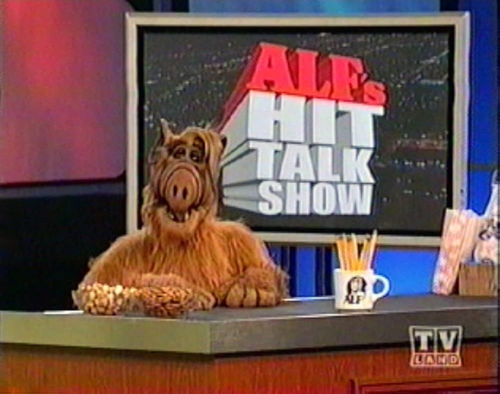An image of ALF behind the desk of his talk show.