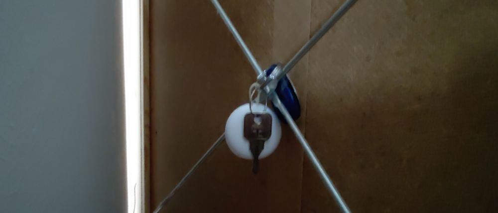a keychain hanging at the back of a cupboard 