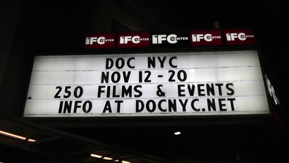 A backlit marquee outside the IFC center reading:
DOC NYC
NOV 12-20
250 FILMS & EVENTS
INFO AT DOCNYC.NET