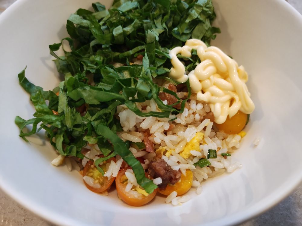 A bowl of BLT fried rice topped with lettuce and Kewpie mayo.
