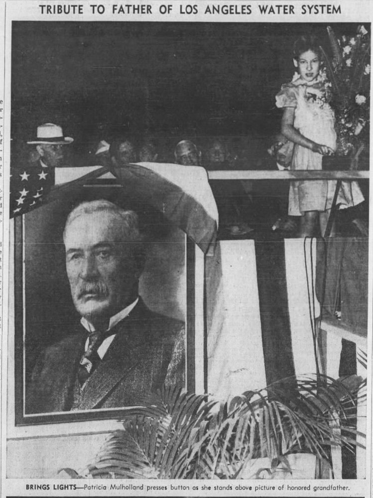 Newspaper photo of Patricia Mulholland standing near a portrait of her grandfather William Mulholland, from the Los Angeles Times (August 2, 1940)