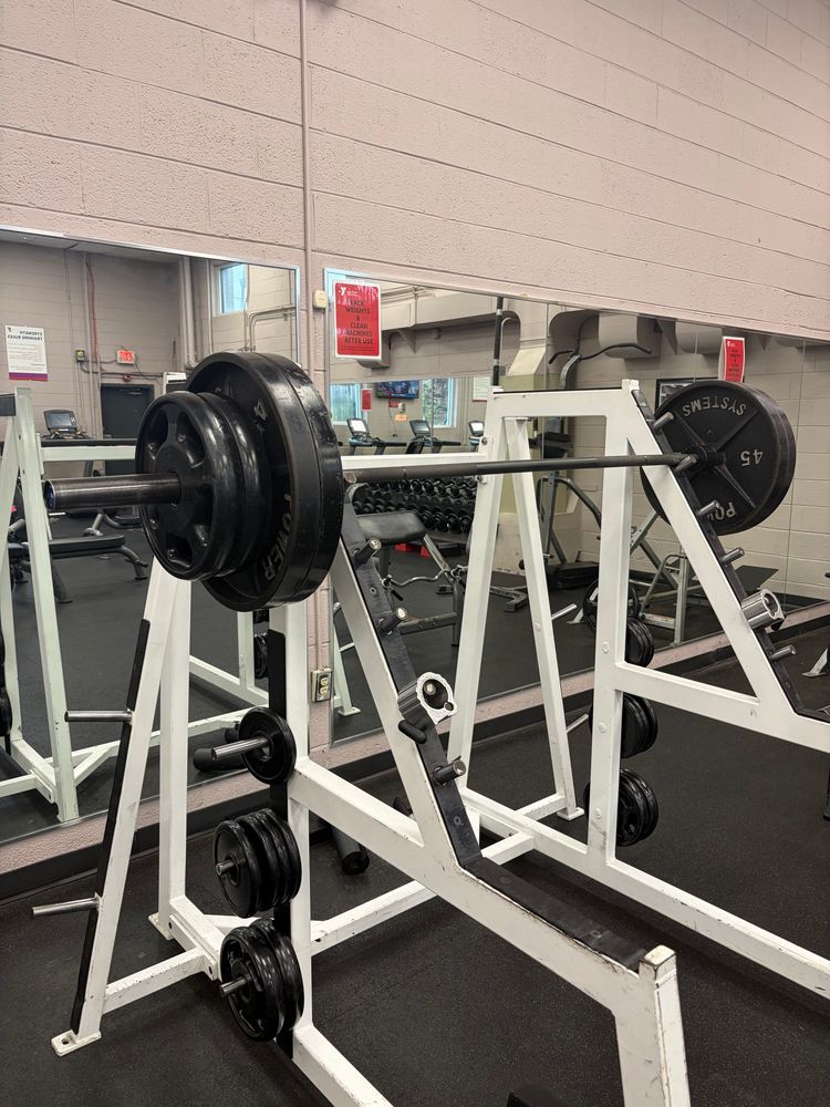 A squat rack with a barbell loaded with 325 pounds.