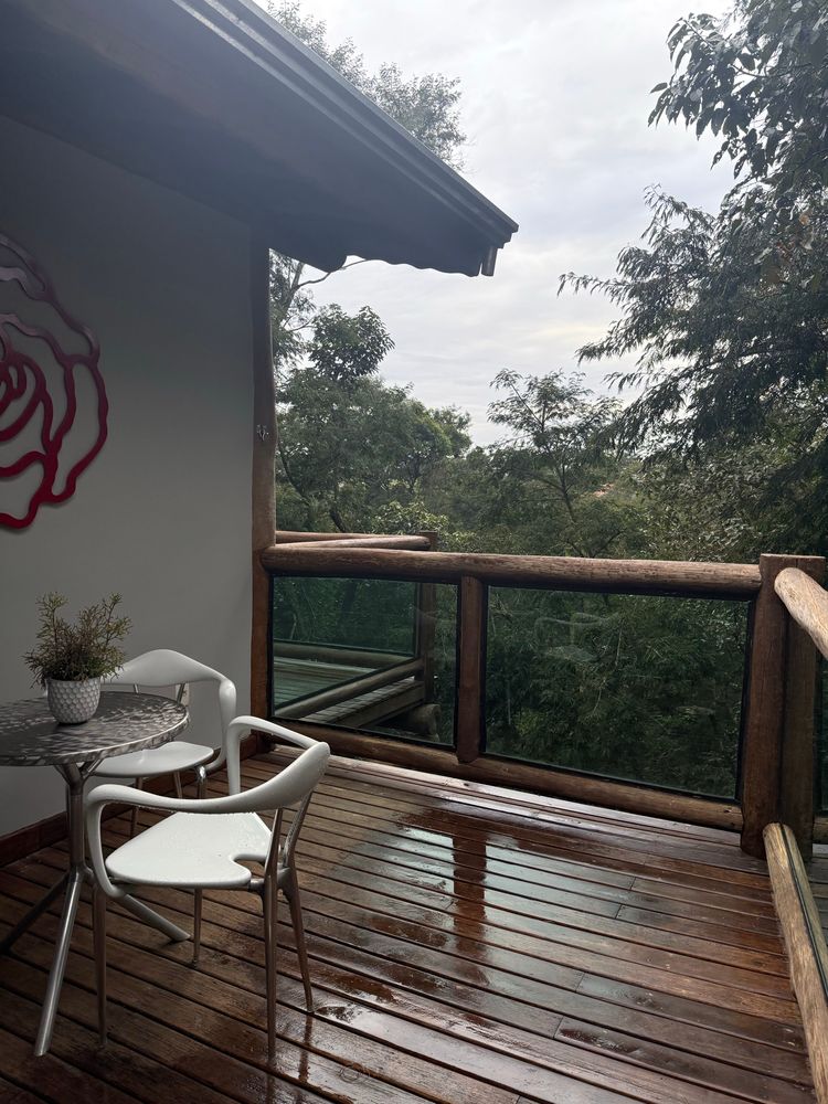 the porch, which shows a little table and chairs, a giant "Rose" outline piece of art, and a cabin-style porch that wraps around the house. You can see the nature preserve just outside the porch (we are on the very edge and on a mountain hillside)