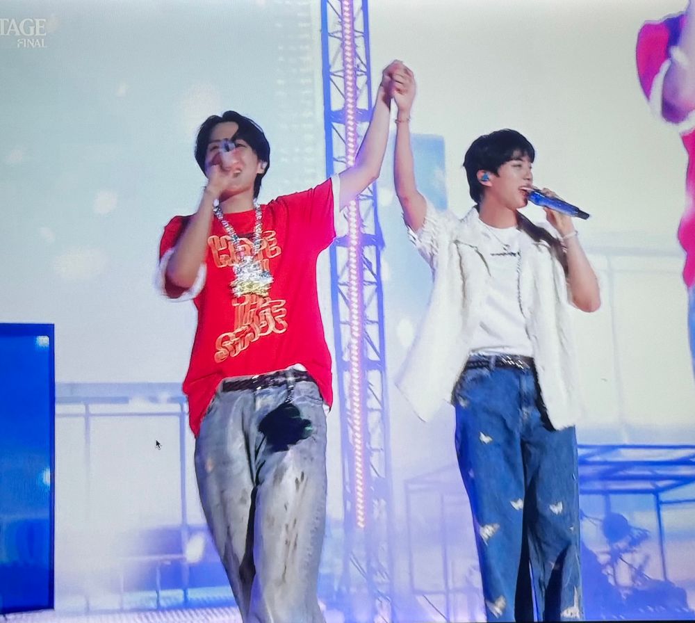 hobi and jin holding hands in the air during the end of spring day 