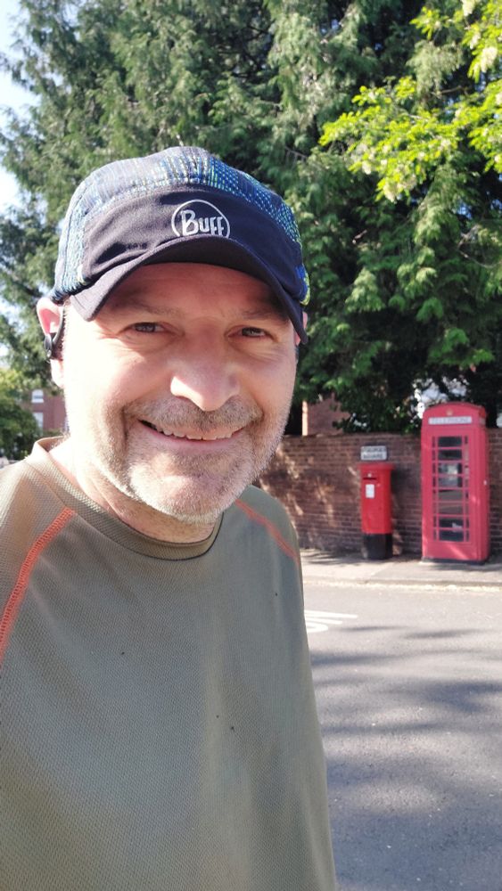 Tony Frobisher in front of a red post box and a red phone box.