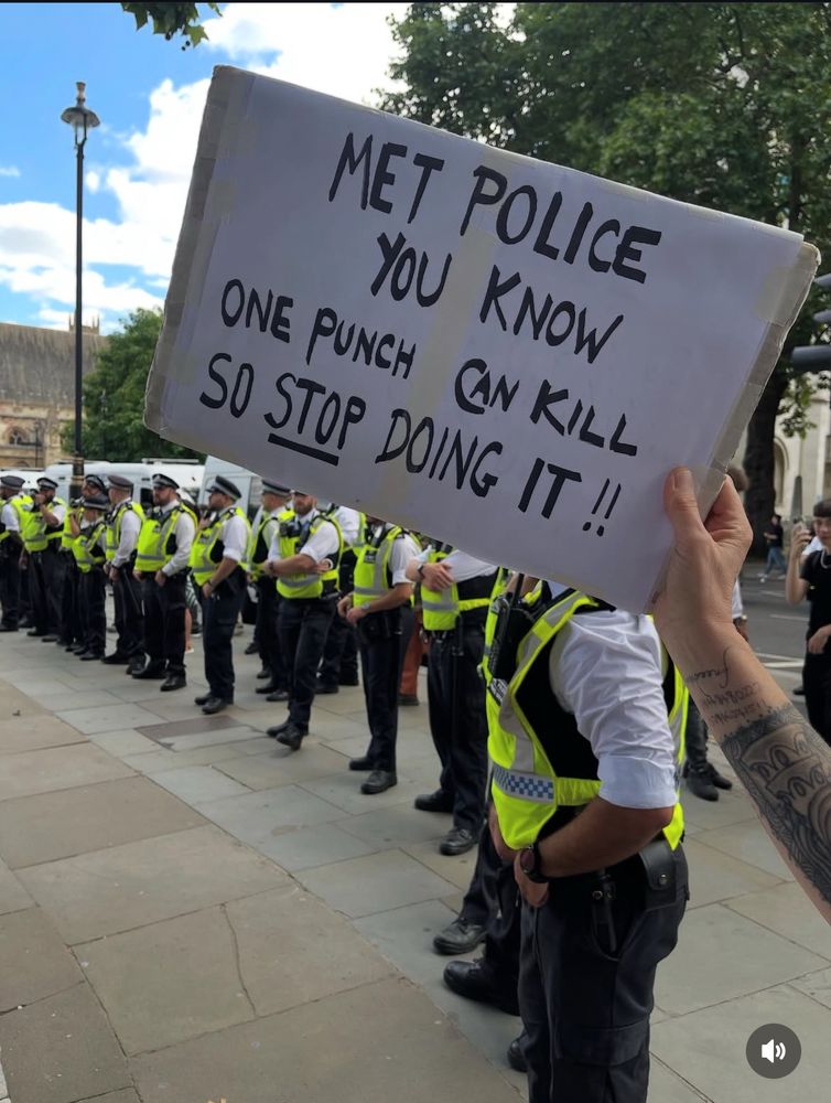 Sign from yesterday not mine, line of police officers and guy holding sign: Met Police you know one punch can kill, so stop doing it 