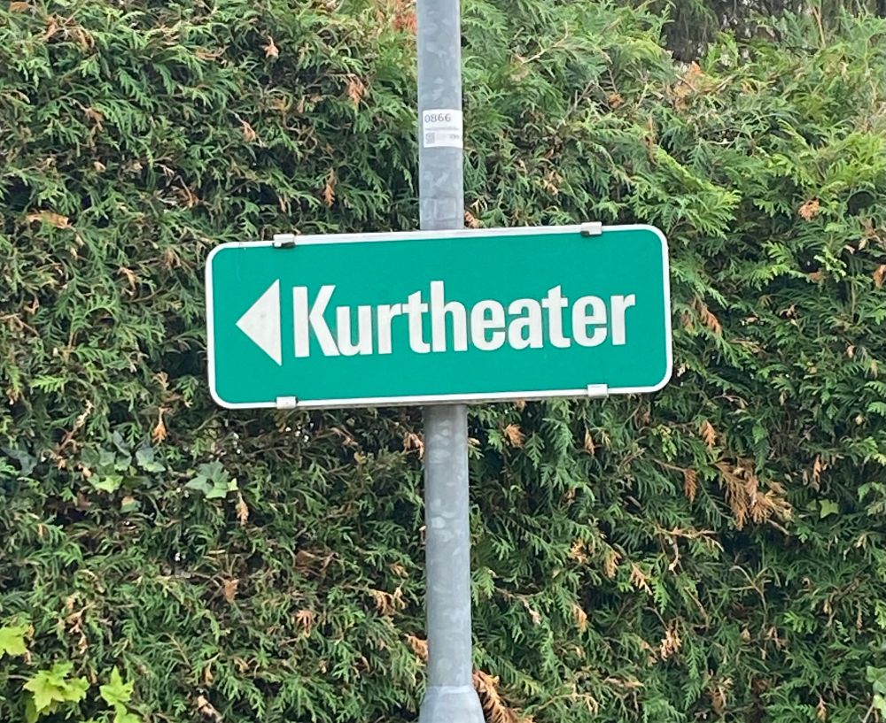 Grünes Schild mit Richtungspfeil und der Aufschrift: Kurtheater