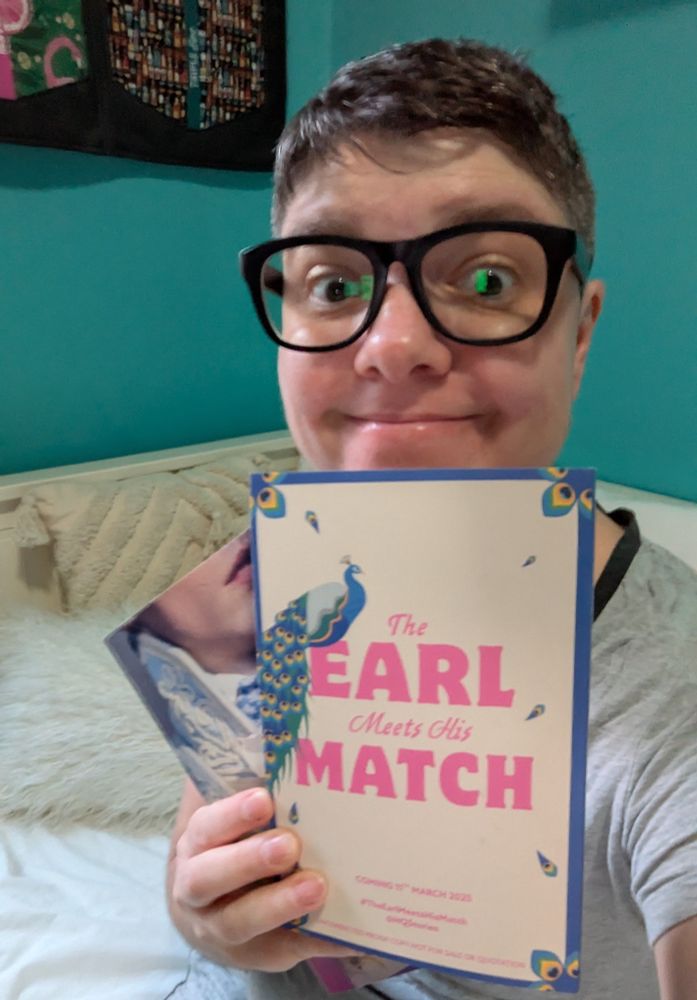 me, a white nonbinary person with glasses, holding up an ARC of The Earl Meets His Match with an ARC of A Gentleman's Gentleman behind it.