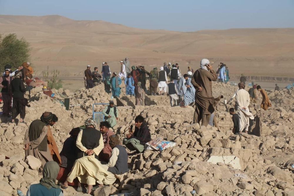 Bild aus dem Erdbebengebiet bei Herat, Menschen stehen auf den Trümmern ihrer Häuser.