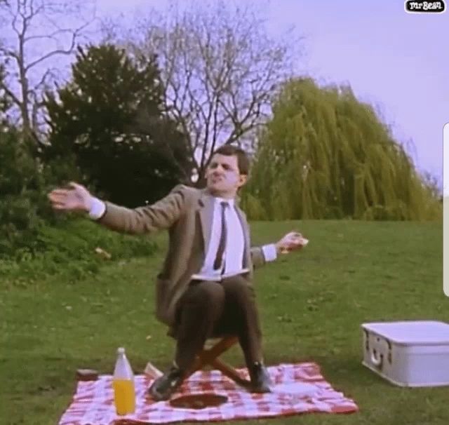 a man sitting on a picnic blanket with his arms outstretched