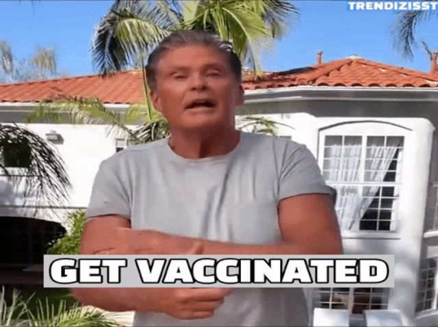 a man standing in front of a house with the words get vaccinated written on the bottom