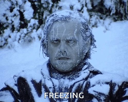 a man is covered in snow and the word freezing is on the bottom