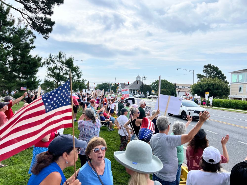 People with signs along the road