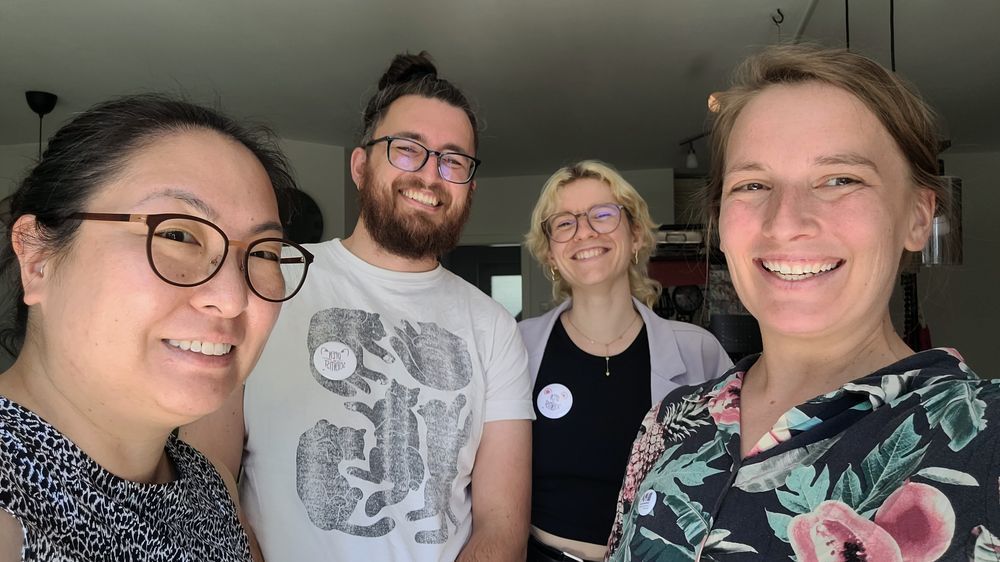 Picture of our team making buttons and wearing them. First right is Heidi, second right is Julia, second left is Danny and first left is Joyce