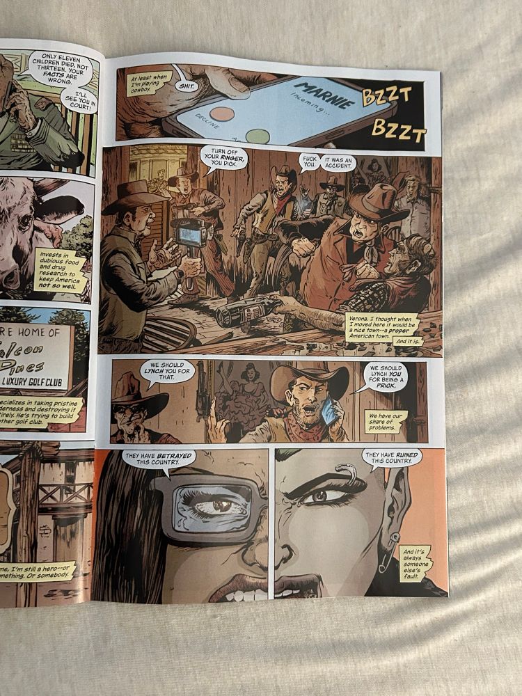 This comic page captures a moment of intense conflict, opening with a phone displaying "MARNIE Incoming..." amidst an argument between angry cowboys. One shouts about "accidents" and "lynching," while another laments that they "moved here it would be a nice town." The artwork shifts to intense close-ups of eyes reflecting betrayal and anguish, with captions like "THEY HAVE BETRAYED THIS COUNTRY" and "And it's always someone else's fault." The overall mood is one of heated dispute and disillusionment.