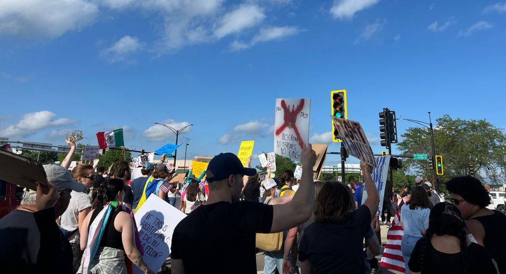 Image of protestors holding various signs for no kings protest 