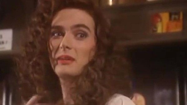 david tennant with long curly hair and a femme outfit