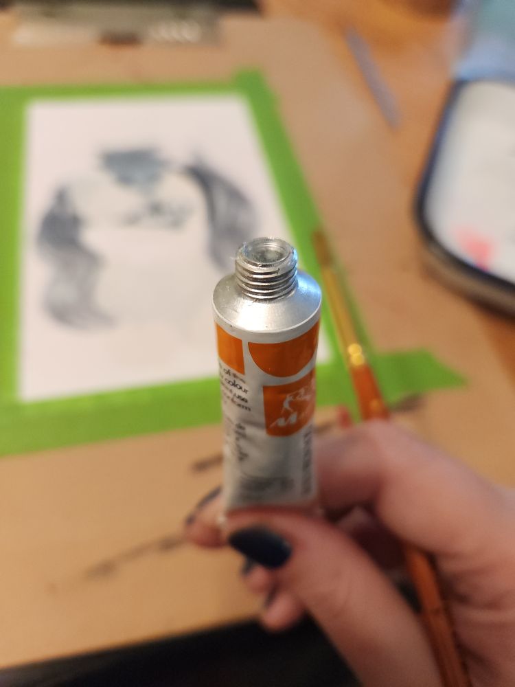 A tube of unopened orange goauche 