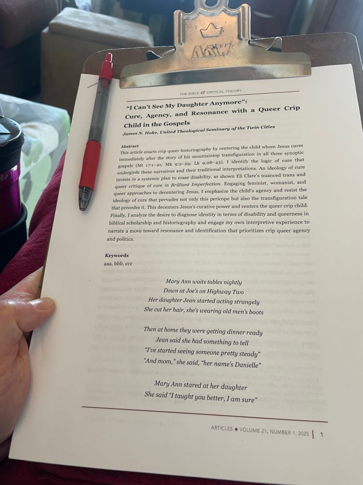 Article on a clipboard with red pen. Title: “‘I can’t see my daughter anymore’: cure, agency, and resonance with a queer crop child in the gospels” Journal: Bible and critical theory