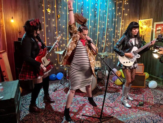 Image of feminist punk performers, imitating riot grrrrl and bringing to life one of the songs from Newitz's book.