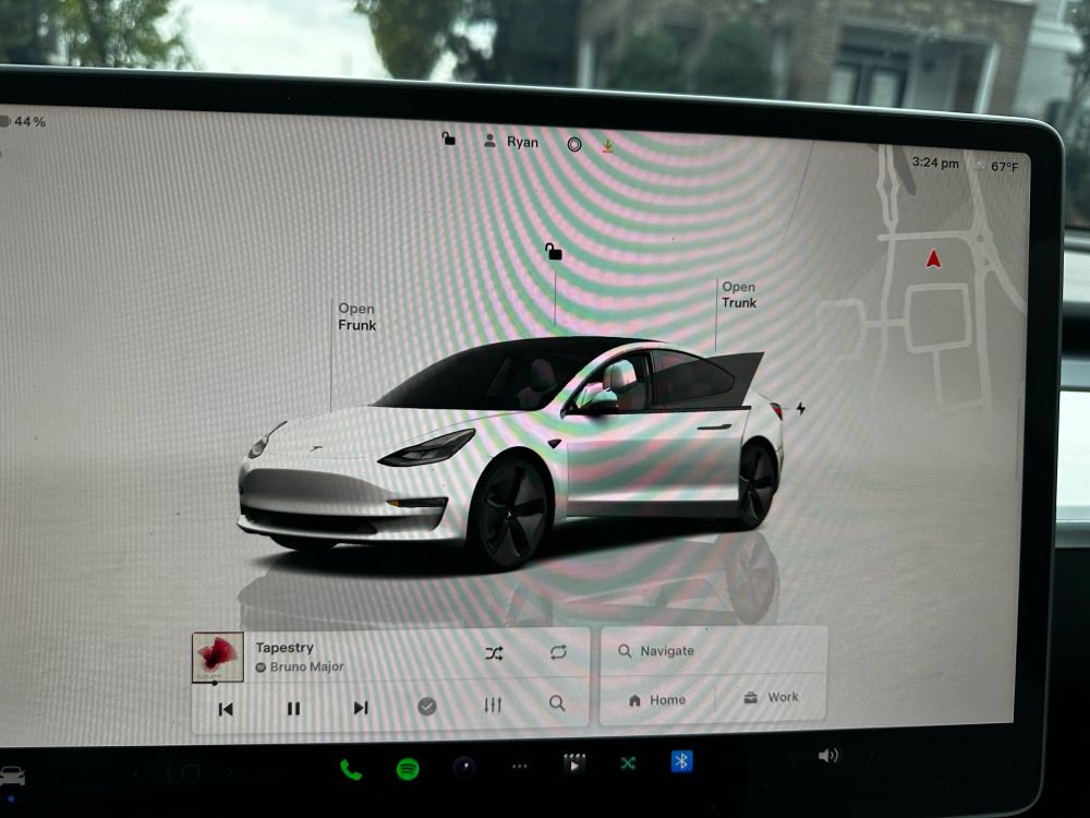 Tesla screen in car with picture of car on it like a dashboard