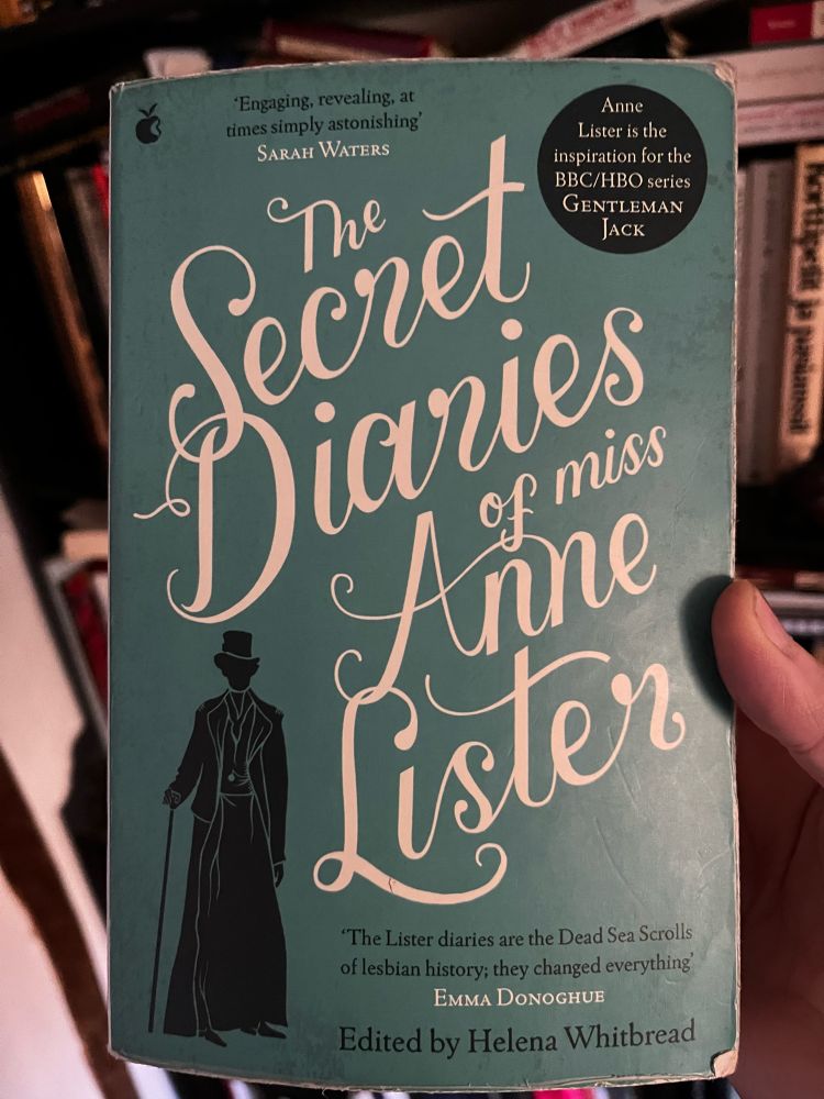 A book cover with green hue, a silhouette of a smarly dressed woman with a cane and a top hat, the text in curly font reads:
'Engaging, revealing, at times simply astonishing'
SARAH WATERS
The Secret Diaries of Anne
Lister
'The Lister diaries are the Dead Sea Scrolls of lesbian history; they changed everything
EMMA DONOGHUE
Edited by Helena Whitbread
