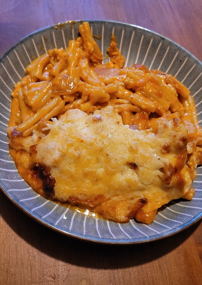 Bowl of homemade caramelised kim chi macaroni cheese with a layer of melted crusty cheese. 