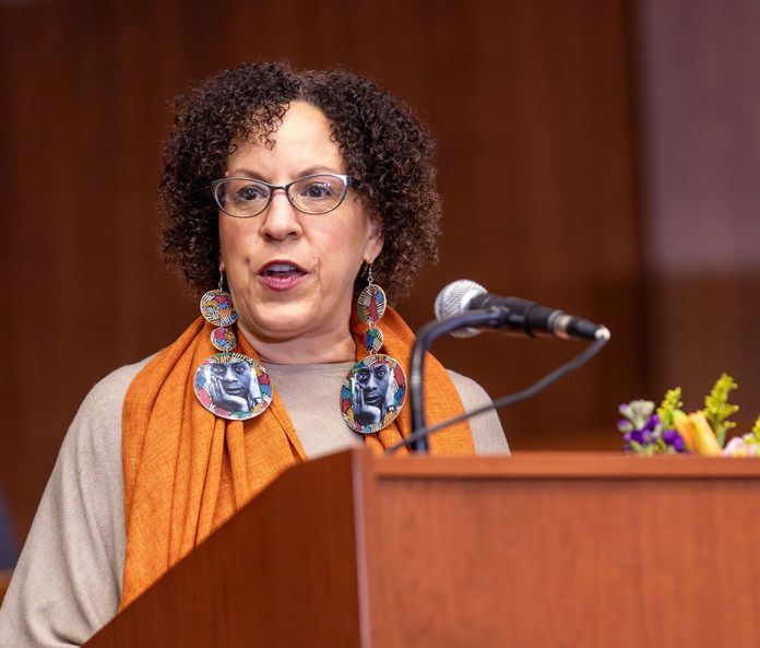 P. Gabrielle Foreman standing at a podium and speaking into a microphone