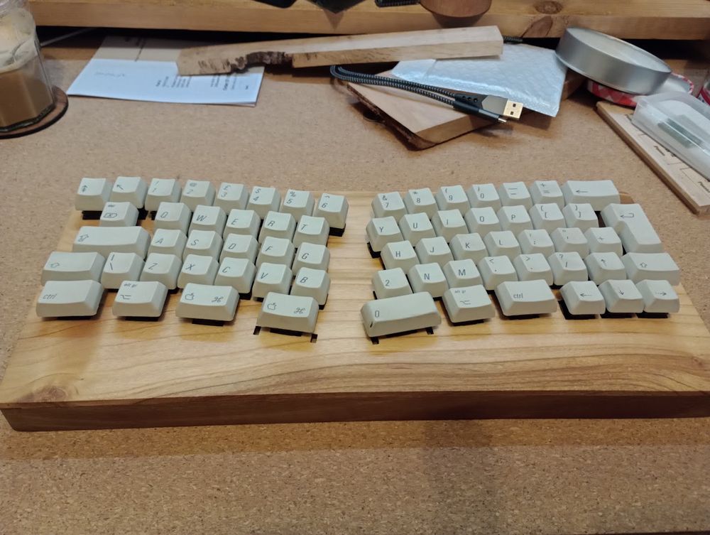 Wooden keyboard with vintage apple keycaps. Keys split into two curved sections for the left and right hand.