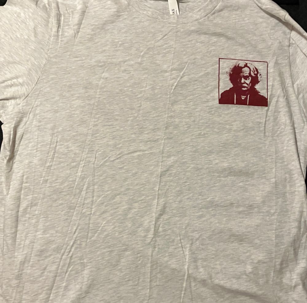 Front of the shirt with The American Vandal logo on the right breast side (left, when worn) of Mark Twain wearing a hoodie and studio headphones