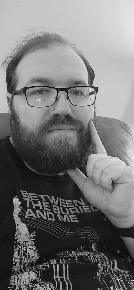 Glasses wearing fella in his 30's wearing a Between the Buried and Me shirt in a black & white selfie (rare to take selfies at all) 