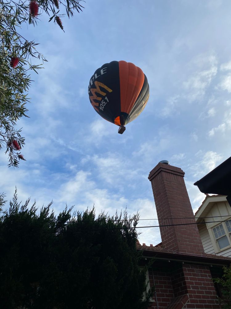 Hot air balloon flying low overhead 