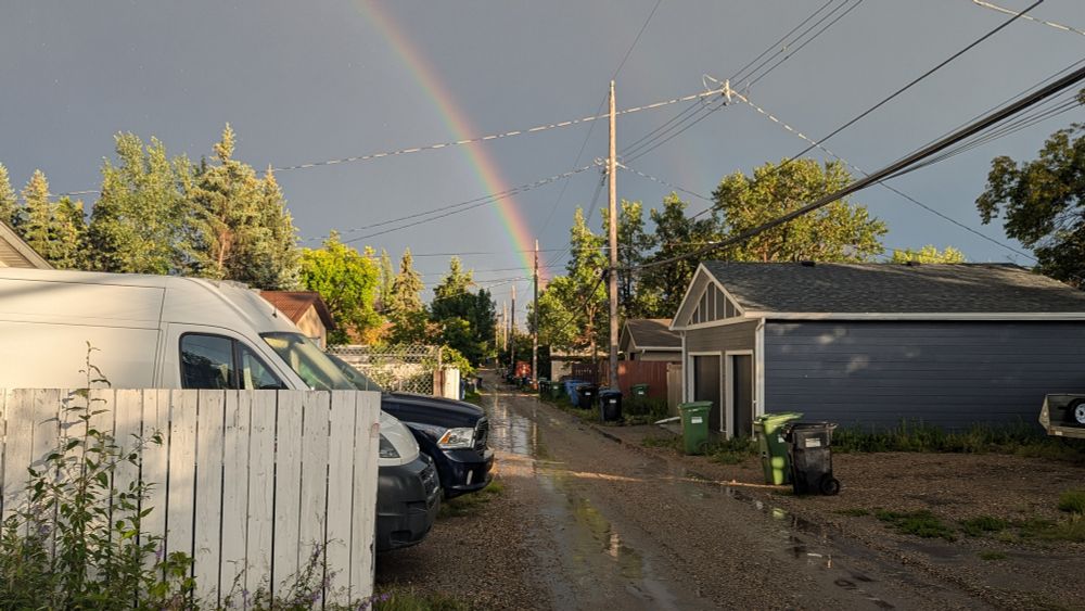 Rainbow ending in an alleyway.