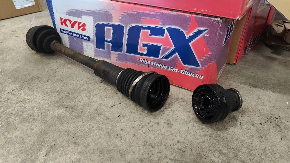 image of a snapped axle on a cement floor with a kyb agx box in the background. looks like the inner spline has backed into the axle itself (weird af) and it allowed the axle to break in two