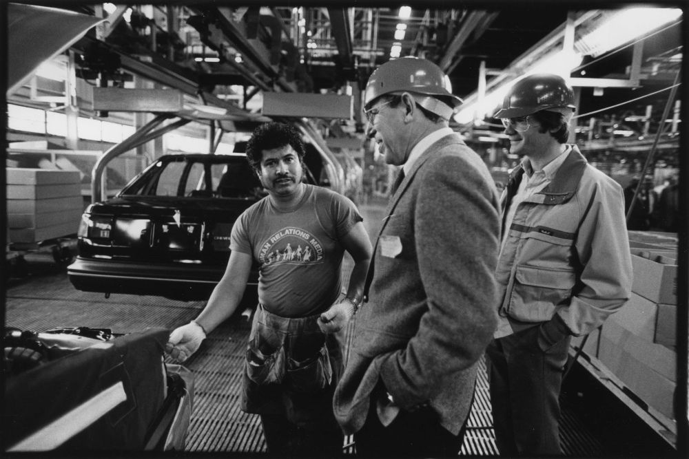 A UAW Local 2244 member describes his job helping to assemble Nova automobiles to UAW Vice President Steve Yokich (center) and UAW Local 600 President Bob King. Yokich, Director of the Skilled Trades Department and King participated in a tour by the International Skilled Trades Advisory Committee at the NUMMI plant in Fremont, California, March 1986. Photo courtesy of the Walter P. Reuther Library. 