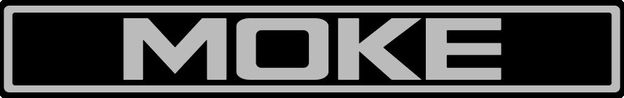 a silver on black simulated car badge, with the word MOKE centred in heavy capital letters